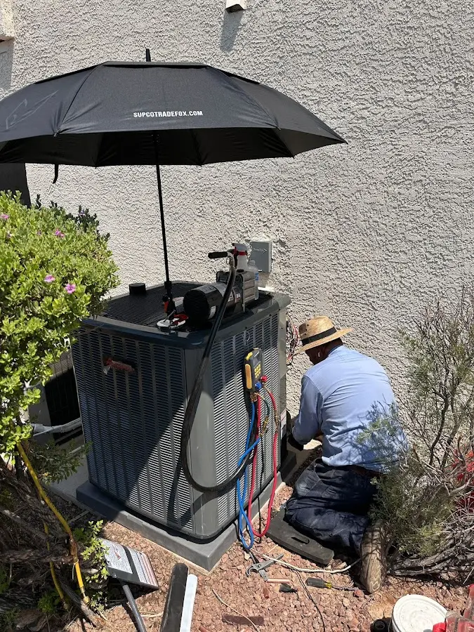 HVAC technician performing outdoor AC maintenance in Sabattus